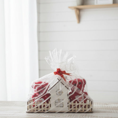 Gift wrapped in a decorative box with cellophane on a white surface.