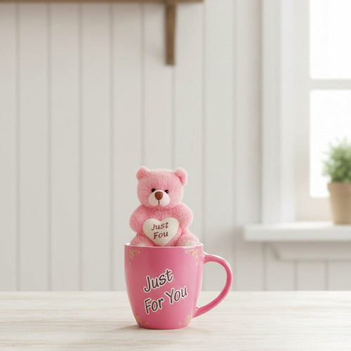 Pink teddy bear in a pink mug with 'Just For You' text on a white surface.